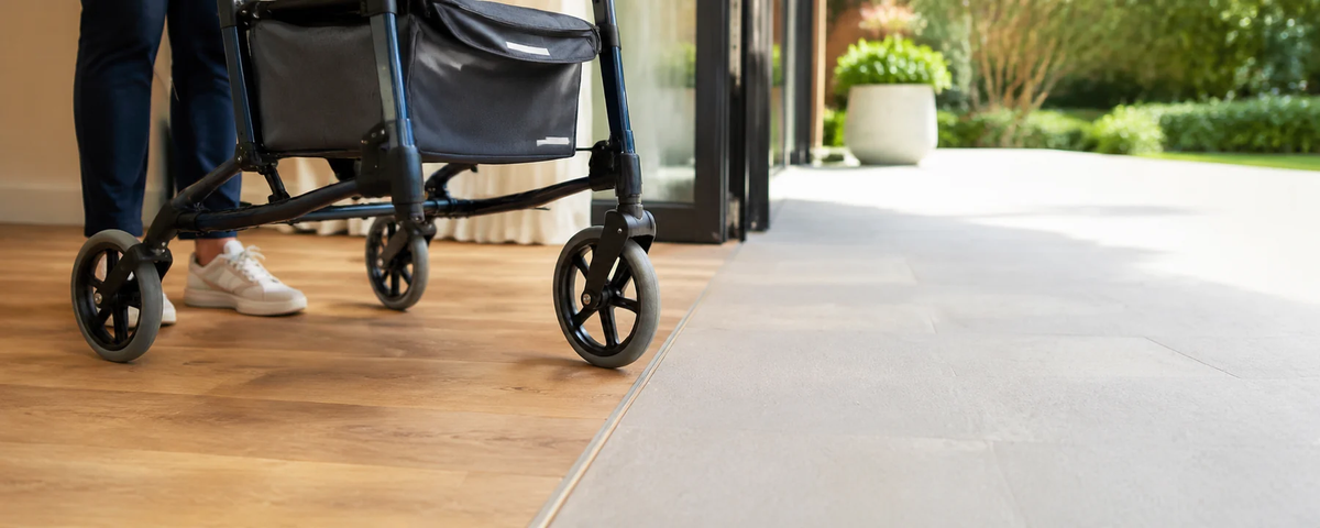 Rollator walker approaching a level indoor-to-outdoor floor transition near an open patio doorway.
