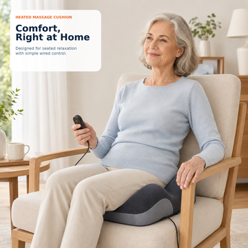 Senior woman relaxing at home sitting on an armchair using the DeepTireh heated massaging seat cushion with handheld remote.